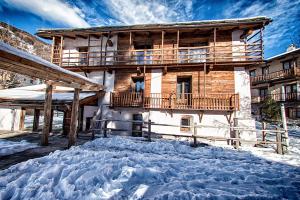 uma casa com neve em frente em Agriturismo Rivet d'Or em Pragelato