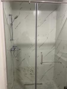 um chuveiro com uma porta de vidro na casa de banho em Park D-plus Apartments Cantonments em Acra