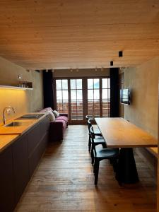 una cucina con tavolo in legno e una sala da pranzo di YETI Design mountain apartments a Valdidentro