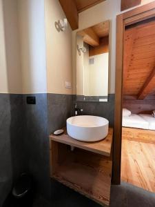 bagno con lavandino bianco e specchio di YETI Design mountain apartments a Valdidentro