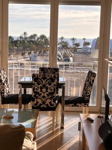 a room with a table and chairs and a balcony at Vinaros Coquet appartement vue mer in Vinaròs