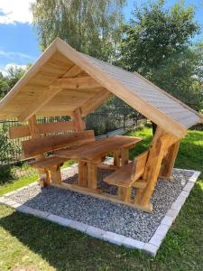 una mesa de picnic de madera con techo en la parte superior en Klimatyczny dom w Wąchocku, en Wąchock