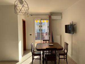 een eetkamer met een tafel en stoelen en een televisie bij Casa Giacobelli in Mola di Bari