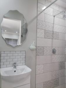 een witte badkamer met een wastafel en een spiegel bij Biki Plek in Kimberley
