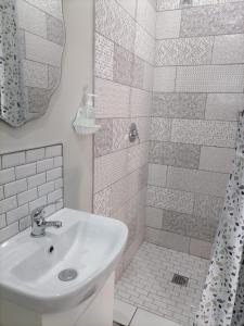 a white bathroom with a sink and a shower at Biki Plek in Kimberley