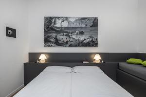 una camera da letto con un letto e un quadro sul muro di Bertamini Apartments a Torbole