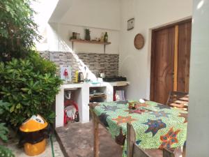 eine Küche mit einem Tisch und einem Kamin in einem Zimmer in der Unterkunft Moringe Home Stay - Village House in Jambiani