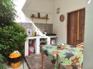 a kitchen with a table and a fireplace in a room at Moringe Home Stay - Village House in Jambiani