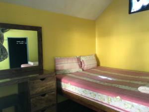 ein kleines Schlafzimmer mit einem Bett und einem Spiegel in der Unterkunft Island Lodge in Ko Chang