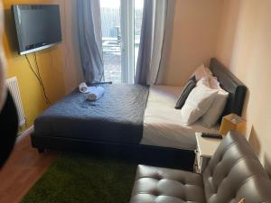 a bedroom with a bed and a tv and a couch at New Cross Hospital - 4 Bedrooms, 2 Bathrooms, Free Parking in Wolverhampton