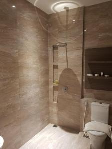 a bathroom with a toilet and a glass shower at Sanghyang Indah Spa Resort in Anyer