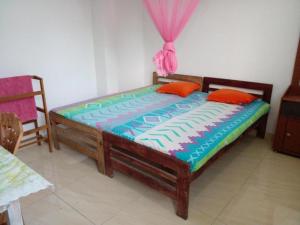 1 dormitorio con cama de madera en una habitación en Jayanthi Surf Dreams, en Midigama East