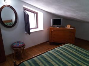 a bedroom with a bed and a tv and a mirror at La Nicchia in Gerace