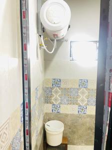 a bathroom with a toilet and a light on the wall at Gautam house in Bhairāhawā