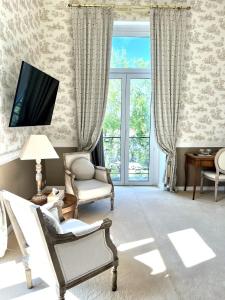a living room with a chair and a tv on a wall at Le Clos du Roc in Montlouis-sur-Loire