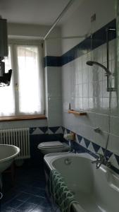 y baño con bañera, aseo y lavamanos. en Appartamenti hotel ortles en Cogolo