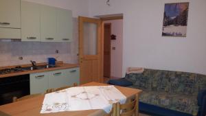 a kitchen and living room with a table and a couch at Appartamenti hotel ortles in Cogolo