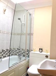 uma casa de banho com uma banheira, um WC e um lavatório. em Nice Double Room London Rental em Londres