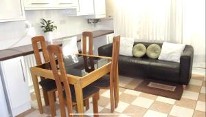 a living room with a table and a black couch at Nice Double Room London Rental in London