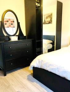 a bedroom with a black dresser and a mirror at Nice Double Room London Rental in London