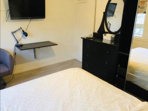 um quarto com uma cama e uma cómoda com um espelho em Nice Double Room London Rental em Londres