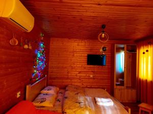 a bedroom with a bed with a christmas tree in it at sweet village in Tsqaltubo
