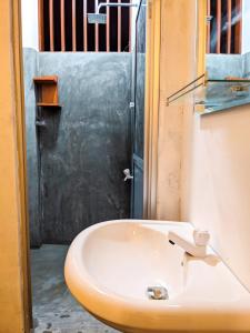 Baño con lavabo junto a una puerta en Light house beach home en Matara