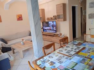 uma sala de estar com uma mesa e uma televisão em Central Home Kavala "private parking" em Kavala