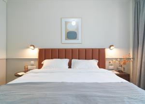 a bedroom with a large bed with white sheets at LIV The City Suites ADULTS ONLY in Larnaka