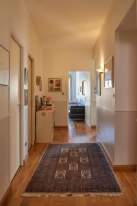 a hallway with a rug on the floor and a refrigerator at Chambre d'Elvire in Albi