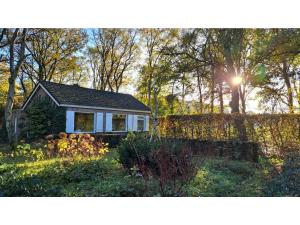 a small house in the middle of a garden at lovely house located in a private natural area in Vessem
