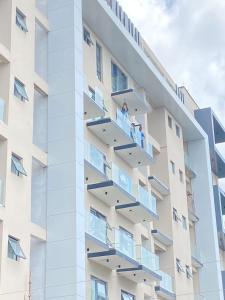uma fachada de um edifício com pessoas nas varandas em Park D-plus Apartments Cantonments em Accra