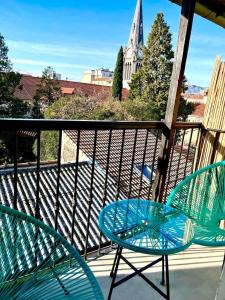 un balcón con 2 sillas, una mesa y una iglesia en Superbe T2 centre ville dernier étage avec balcon, en Valence