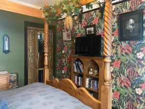 1 dormitorio con cama y pared de flores en Dracula Rooms, en Whitby
