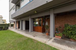 a brick building with a brown door and some plants at [Duca d'Aosta - il soffio del mare] in Viareggio