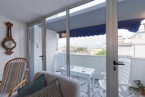 a living room with a sliding glass door and a table at [Duca d'Aosta - il soffio del mare] in Viareggio