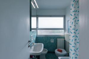a bathroom with a sink and a toilet and a window at [Duca d'Aosta - il soffio del mare] in Viareggio +17 photos