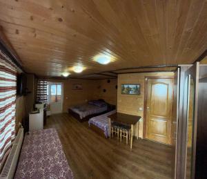 ein Schlafzimmer mit 2 Betten und einem Tisch in einem Zimmer in der Unterkunft Sadyba Markevychiv ЧАН БАНЯ ЯРЕМЧЕ in Jaremtsche