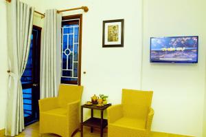 2 sillas amarillas y una mesa en una habitación en An Hoi Town Homestay, en Hoi An