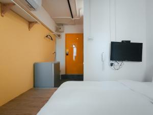 a room with a bed and a tv on a wall at Taipei Inn in Taipei