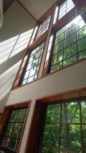 Oak Villa Nasu 抜群のプライベート空間 100インチ映像 轟音サウンド 人工芝デッキ في ناسو: مجموعة من النوافذ في مبنى به أشجار