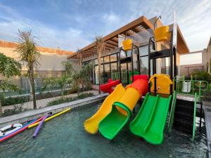 a pool of water with a playground with slides at Villa Bali Jeddah in Jeddah