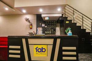 a bar in a hotel with a staircase behind it at FabHotel AGK in Haridwār