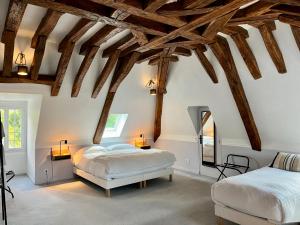 a bedroom with two beds and wooden beams at Le Clos du Roc in Montlouis-sur-Loire