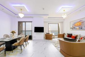 een woonkamer met een tafel en stoelen en een bank bij JBR The Walk Shams 4 - Fully Upgraded Sea view Lux 2 bedroom By Gardenia Holiday in Dubai
