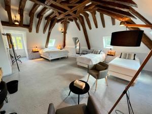 a living room with two beds and a flat screen tv at Le Clos du Roc, Maison d'hôtes in Montlouis-sur-Loire