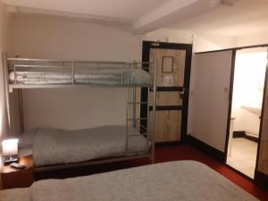 1 Schlafzimmer mit 2 Etagenbetten und einer Tür zu einem Zimmer in der Unterkunft Le Grand Cerf in Nonancourt