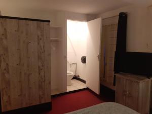 a bedroom with a bathroom with a toilet and a sliding door at Le Grand Cerf in Nonancourt