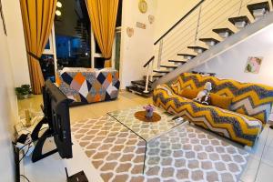 a living room with a couch and a television at Elegant 5STAR Resort Suite Mid Valley KL Sunway by Stayz Suites with Shopping Complex in Kuala Lumpur +75 photos