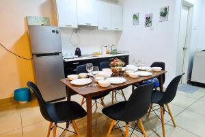 a kitchen with a table with chairs and a refrigerator at Elegant 5STAR Resort Suite Mid Valley KL Sunway by Stayz Suites with Shopping Complex in Kuala Lumpur